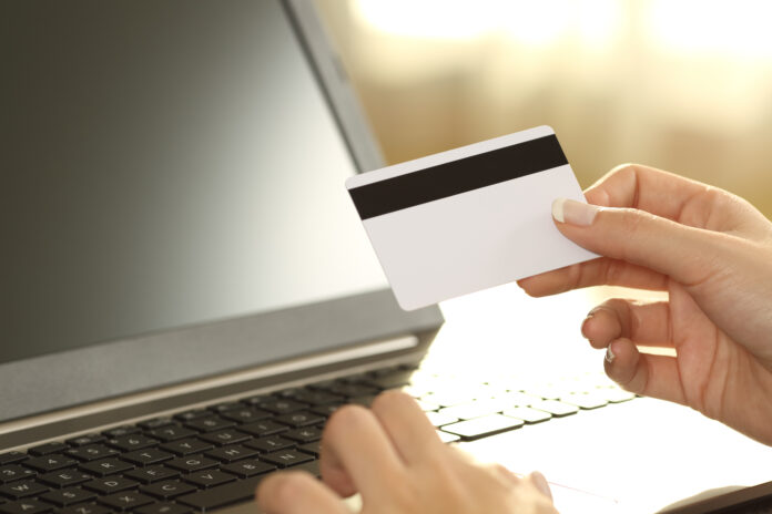 Girl,Hands,Holding,Credit,Card,And,Buying,On,Line,Sitting