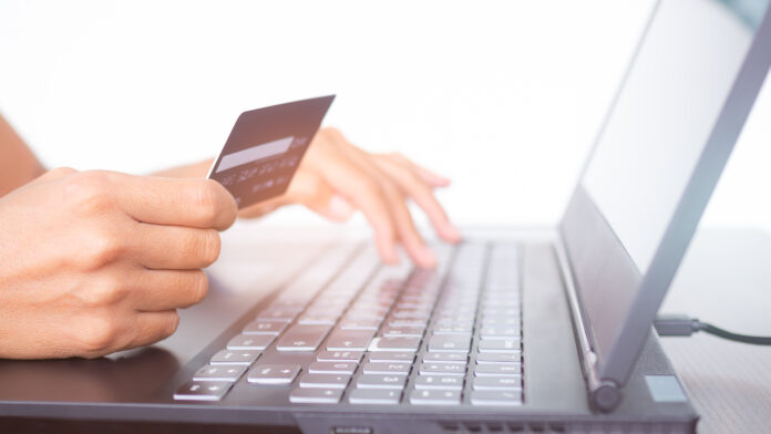 Hand,Holding,Credit,Card,And,Typing,Keyboard,Laptop,Computer.,Shopping