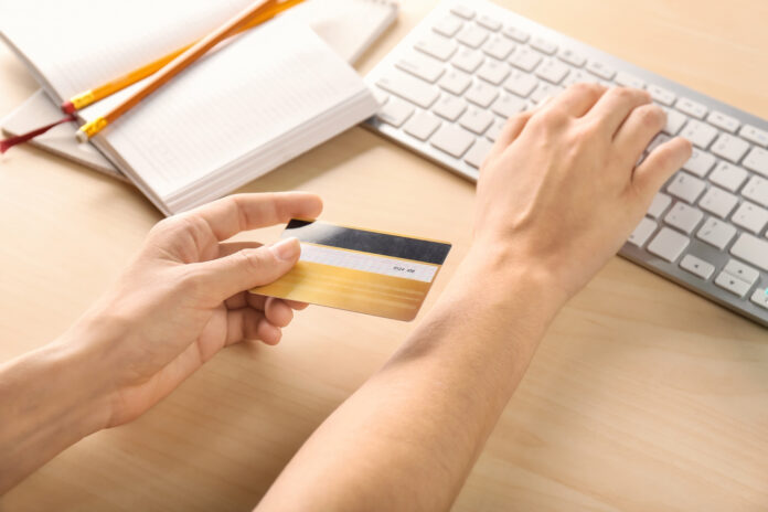 Woman,With,Credit,Card,Using,Computer,At,Table