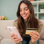 Young,Caucasian,Woman,Using,A,Smart,Phone,To,Make,An