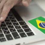 Man,Pays,Online,With,Plastic,Bank,Card,With,Printed,Flag