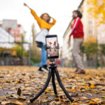 Young,Couple,With,Smartphone,Making,Video,For,Social,Media,Outdoors